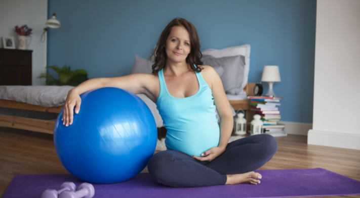 Femme enceinte sur tapis de yoga, ballon d'exercice